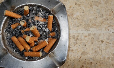 ashtray made of metal full of cigarette butts