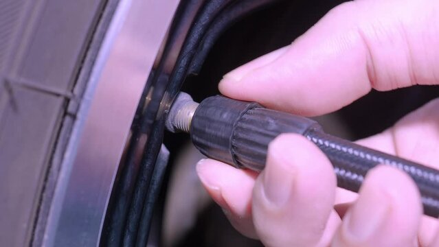 Inflating tire. Filling air in the tires before travel. man hand open valve cap and inflate car tyre before driving. checking car wheel air pressure using gauge. Automotive vehicle. Car wheel air fix.