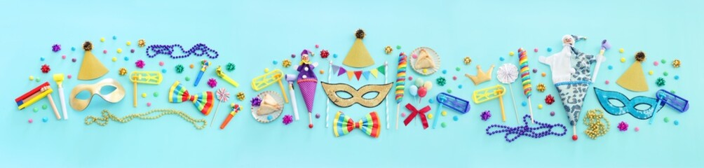Purim celebration concept (jewish carnival holiday) over blue wooden background
