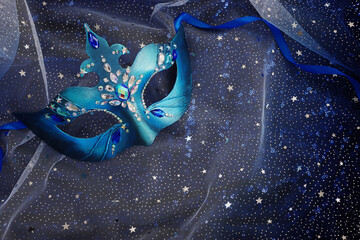 Photo of elegant and delicate Venetian mask over blue dark stars background