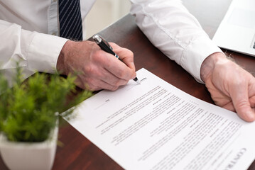 Hand of businessman signing a document (Lorem ipsum text used)