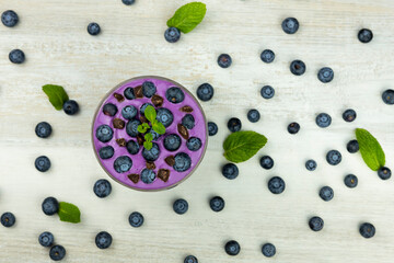 Smoothie or pudding with blueberries and chocolate served in a bowl for breakfast. Flat lay image