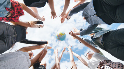 Fototapeta na wymiar Female student girls standing in a circle toss the world globe up.
