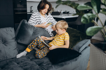 children at home, sitting on the couch, playing with gadgets