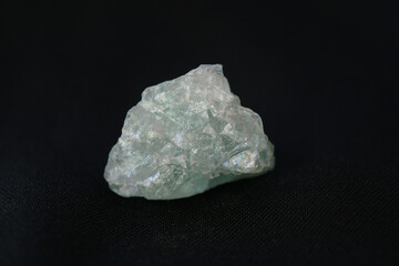 Macro shooting of raw green flourite stone isolated on black canvas background. raw gem stone. 