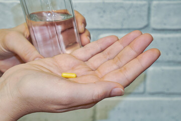 Female hands, pill and glass with water