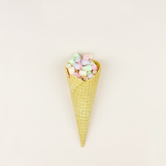 Wafer horn and marshmallow on a pastel background, top view, flat lay, minimalist trend, concept of sweet dessert.