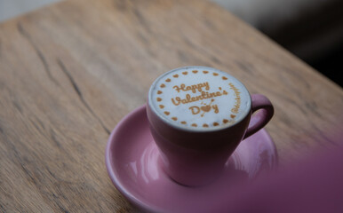 Pink cup of cappucino with signature happy valentine's day.
