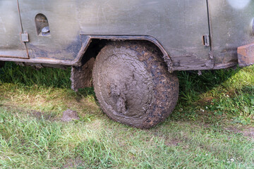 Fototapeta na wymiar Dirty wheel of an old SUV in mud