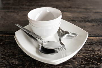Cups, plates, spoons, forks arranged on the table.