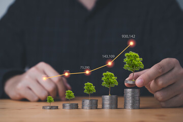 Businessman or fund manager stacking coins with tree plant and increasing graph for growth business...