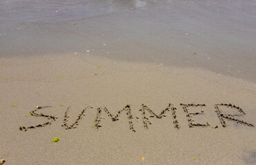 The inscription on the sand Summer symbolizes a summer vacation at the sea