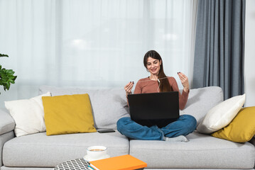 Fototapeta premium Young sick college student woman sitting at home and preparing for online education class over the video conference call on her laptop computer. Online internet education, health care concept.