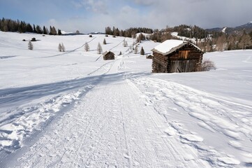 Traumhaft sch&ouml;n gelegene Almen auf den  winterlichen Armentara Wiesen am Heiligkreuzkofel in den Dolomiten w&auml;hrend einer Winterwanderung 