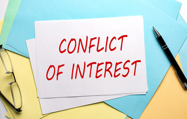 CONFLICT OF INTEREST text on paper on colorful paper background