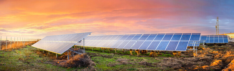Solar panels on sunset. Industrial landscape with photovoltaic power plant. Environmental concept....