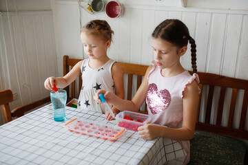 Funny children play with hearts and water at home in the kitchen. Educational classes and...