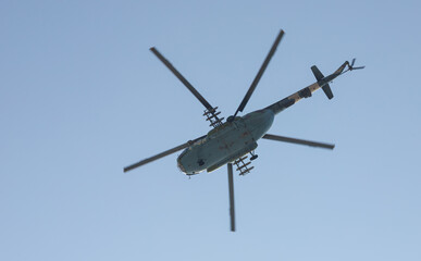 The military helicopter against the blue sky