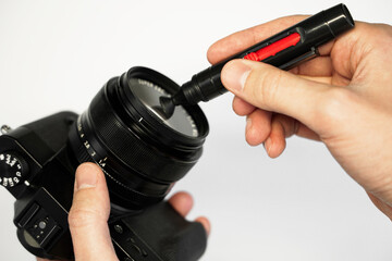 a man cleans a reflex camera with a brush from dust camera service