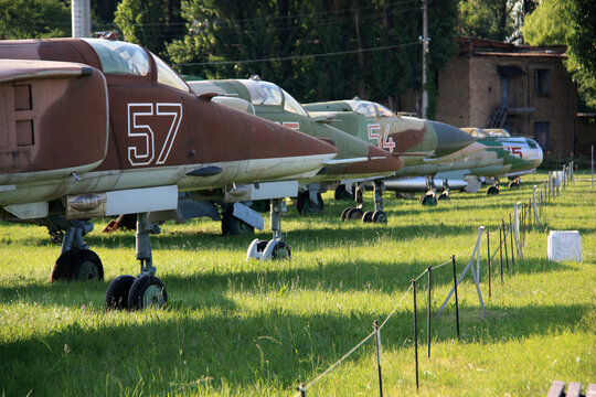 View of MiGs parked in line at the Ukraine State Aviation Museum - MiG-27 and MiG-23 in the foreground, MiG-21, MiG-19 and MiG-17 in the background
