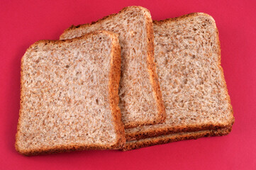 Tranches de pain de mie en gros plan sur fond rouge