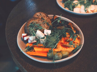 Balanced breakfast on the table. Delicious salad and vegetables with hummus and artisan bread