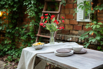 A bouquet of red poppies in a glass vase. Flowers in a vase at home. Interior Terrace, patio. Wooden table and plates for garden party or dinner. Table for lunch outside in garden in yard of house.	
