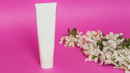 Cosmetic cream tube packaging on pink background. Beauty, skincare and natural cosmetics concept. Mockup for design. Spring cosmetic sale. copy space. Womens day.