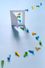 Enter the door of house on blue by bolts as visitor Creative concept. Balance, shadows Step by step into opened entrance progress, colorful screw and building, construction improvement tool Copy space