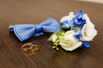 Groom's morning. Wedding accessories in blue colors. Tie-butterfly, rings and boutonniere