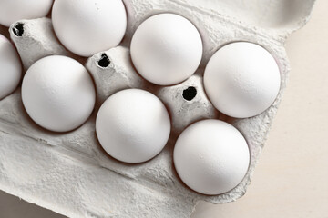 Part of a cardboard box with fresh white eggs, ingredient for cooking, baking, breakfast and Easter, high angle view from above, selected focus