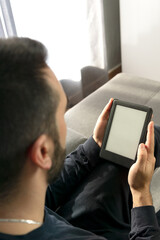 Unrecognizable young boy reading her electronic book in a moment of relaxation