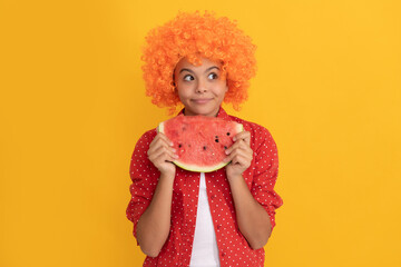 happy child in fancy orange hair wig hold fresh ripe water melon slice fruit, organic food