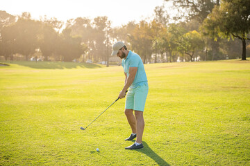 male golf player on professional golf course. portrait of golfer in cap with golf club.