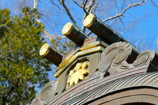 Roof design image of the Japanese Kamakura period wooden shrine architecture. With trees an sunny sky background.