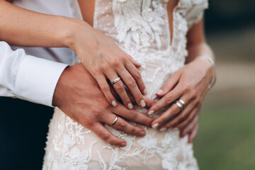 newlyweds husband and wife hugging. wedding rings close-up. faceless.