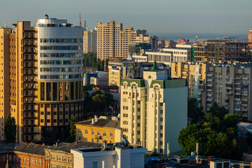 Voronezh, Russia, June 18, 2019: View from the window of skyscraper on city. Modern high-rise buildings against blue sky. Close-up of round building.
