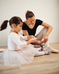 Young mother and 3 years old daughter dancing classical ballet at home