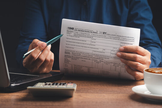 Businessman using a tax form to complete individual income tax payment form.