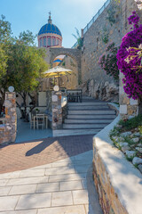 Scenic view of stairs leading to st nikolas church  with  a blooming bougainvillea aside and an extrerior of a traditional  cafe , in ermoupolis  Syros Greece