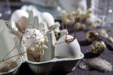 Easter concept. A white egg with copper wire ears and a painted rabbit sleeping face in a box....