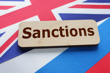 Sanctions are shown by the text with Britain flag and russian flag under it - obrazy, fototapety, plakaty
