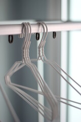 The hangers are hung on the clothesline, illuminated from behind.