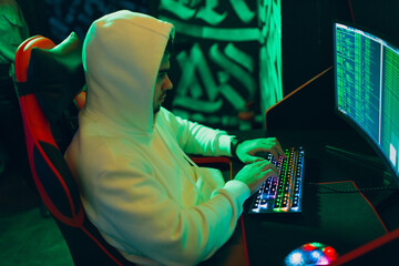 Hacker in hoodie working hacks code site on personal computer laptop