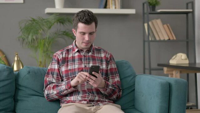 Man having Success on Smartphone at home