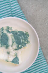moldy yogurt in a bowl on table