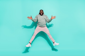 Fototapeta na wymiar Full length body size view of attractive cheery guy jumping having fun isolated over bright teal turquoise color background