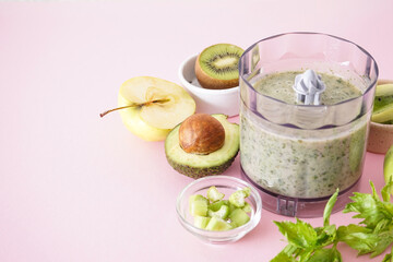 Electric hand blender with fruits and smoothies on a pink background, space for text, close up.