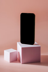 Smartphone with blank black screen. Mobile phone on cube podium.  Pedestal mockup space for display...