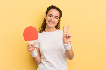 young pretty hispanic woman smiling and looking friendly, showing number two. ping pong concept